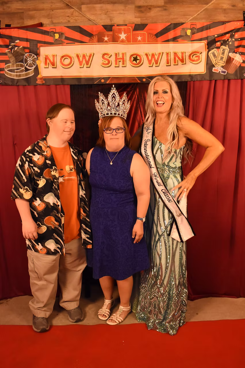 Kristin with two prom guests wearing a crown and sash